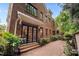 Exterior home view with brick paved patio, brick wall and black framed double doors at 213 Old Franklin Grove Dr, Chapel Hill, NC 27514