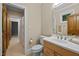 Light filled bathroom featuring a tile floor, wooden cabinet, and large mirror at 213 Old Franklin Grove Dr, Chapel Hill, NC 27514
