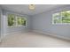 Sun-filled bedroom with blue walls, carpet, and large windows at 213 Old Franklin Grove Dr, Chapel Hill, NC 27514