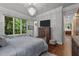 Comfortable bedroom features a large window, chandelier and a decorative painting at 213 Old Franklin Grove Dr, Chapel Hill, NC 27514