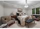 Comfortable bedroom with a chandelier, a window, and a variety of seating options at 213 Old Franklin Grove Dr, Chapel Hill, NC 27514