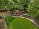 A serene outdoor green space with stone walls, tiered landscaping, and benches for relaxation at 213 Old Franklin Grove Dr, Chapel Hill, NC 27514