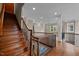 Stairwell with wooden handrail and iron spindles, hardwood floors, and natural lighting at 213 Old Franklin Grove Dr, Chapel Hill, NC 27514