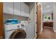 Convenient laundry room with modern washer and dryer, cabinets, and access to kitchen at 213 Old Franklin Grove Dr, Chapel Hill, NC 27514