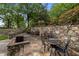 An inviting stone patio with seating, a fire pit, and a charming stone wall backdrop at 213 Old Franklin Grove Dr, Chapel Hill, NC 27514