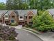 Exterior view of brick townhomes with mature landscaping, trees, and blue sky at 213 Old Franklin Grove Dr, Chapel Hill, NC 27514