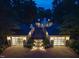 Night aerial view of a luxury home with illuminated garages and manicured landscape at 220 Glandon Dr, Chapel Hill, NC 27514