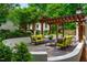 Beautiful outdoor living space with a pergola, comfortable seating, and elegant stone patio at 220 Glandon Dr, Chapel Hill, NC 27514