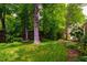 Lush backyard featuring mature trees, a quaint bench, and well-manicured lawn at 220 Glandon Dr, Chapel Hill, NC 27514
