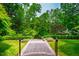 Lush backyard featuring mature trees, manicured hedges, and a stone walkway for serene outdoor enjoyment at 220 Glandon Dr, Chapel Hill, NC 27514