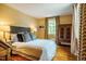 Bright bedroom with hardwood floors, patterned drapes, and a gray headboard at 220 Glandon Dr, Chapel Hill, NC 27514