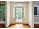 Bright entryway featuring a glass door with sidelights, hardwood floors, and decorative wallpaper in the background at 220 Glandon Dr, Chapel Hill, NC 27514