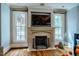 Living room fireplace with decorative mantel, large television, and natural light at 220 Glandon Dr, Chapel Hill, NC 27514