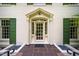Elegant front entrance with a glass door, surrounded by green shutters, decorative stone, and a brick facade at 220 Glandon Dr, Chapel Hill, NC 27514