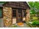Close-up of the front door featuring stone detail, a wooden door, and a welcoming door mat at 220 Glandon Dr, Chapel Hill, NC 27514