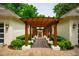 Charming walkway with a pergola, connecting the home's structures and surrounded by lush greenery at 220 Glandon Dr, Chapel Hill, NC 27514