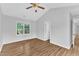 Bright bedroom featuring hardwood floors, a ceiling fan, and large window views at 221 Mint Hill Dr, Cary, NC 27519