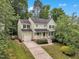 Charming two-story home with landscaped yard and inviting front porch, set against a backdrop of lush greenery at 221 Mint Hill Dr, Cary, NC 27519