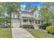 Inviting two-story home featuring a classic front porch and well-maintained landscaping for enhanced curb appeal at 221 Mint Hill Dr, Cary, NC 27519