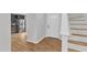 Bright foyer featuring hardwood floors, staircase, and view into modern kitchen with stainless steel appliances at 221 Mint Hill Dr, Cary, NC 27519