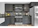A renovated kitchen boasts stainless steel appliances, stone backsplash, and dark grey cabinets at 221 Mint Hill Dr, Cary, NC 27519
