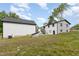Backyard with the home in the background, featuring an outbuilding, grass, and lush trees at 2616 Wedgedale Ave, Durham, NC 27703