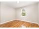 Bright bedroom featuring hardwood floors, neutral walls, and a window overlooking the backyard at 2616 Wedgedale Ave, Durham, NC 27703