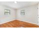 Empty bedroom with hardwood flooring, neutral paint, and two windows that provide ample lighting at 2616 Wedgedale Ave, Durham, NC 27703