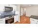 Modern kitchen with stainless steel appliances, herringbone backsplash and hardwood floors at 2616 Wedgedale Ave, Durham, NC 27703