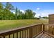 Expansive backyard view with a wooden deck, lush greenery, and clear blue sky at 2617 Chert Ln, Raleigh, NC 27610