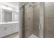 Modern bathroom featuring gray tiled shower with glass door and bright vanity at 2617 Chert Ln, Raleigh, NC 27610
