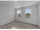 Well-lit bedroom with neutral carpet, two windows, and ample natural light at 2617 Chert Ln, Raleigh, NC 27610