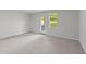 Bright bedroom featuring neutral carpet, a door to the backyard, and a sunny window at 2617 Chert Ln, Raleigh, NC 27610