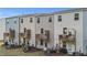 View of a townhome backyard, featuring a private deck, green lawn, and modern exterior at 2617 Chert Ln, Raleigh, NC 27610