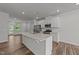 Open kitchen with white cabinets, stainless appliances, and a large center island at 2617 Chert Ln, Raleigh, NC 27610