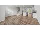 Open-concept living space with hardwood floors, a staircase, and a kitchen with white cabinetry and stainless appliances at 2617 Chert Ln, Raleigh, NC 27610