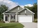 Charming single-Gathering home boasts a manicured lawn, grey siding, and a two-car garage, blending comfort with curb appeal at 280 Babbling Brook Dr, Clayton, NC 27520