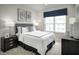 Comfortable bedroom with plush carpet, featuring a large window, a cozy bed, and stylish decor at 2881 Foster Woods Dr, Apex, NC 27502