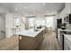 Bright open floor plan with modern kitchen, island seating, dining area and stairs leading to second floor at 2881 Foster Woods Dr, Apex, NC 27502