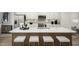 Bright kitchen island features white counter top, a stainless steel sink, and bar stool seating at 2881 Foster Woods Dr, Apex, NC 27502