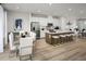 Open concept kitchen and dining area with white cabinets, quartz island, stainless appliances, and modern dining set at 2881 Foster Woods Dr, Apex, NC 27502