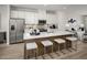 Modern kitchen features a quartz-topped island with seating, stainless steel appliances, and white cabinetry at 2881 Foster Woods Dr, Apex, NC 27502