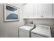 Efficient laundry room featuring modern appliances and ample overhead cabinet space at 2881 Foster Woods Dr, Apex, NC 27502