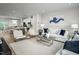 Bright, open-concept living room with white sofas, modern art, and seamless flow to a well-appointed kitchen at 2881 Foster Woods Dr, Apex, NC 27502