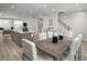 Open concept living space with a dining table, kitchen island, and a staircase at 2881 Foster Woods Dr, Apex, NC 27502