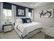 Elegant main bedroom with a king bed, stylish blue accents, and a well-lit ambiance for a restful night at 2881 Foster Woods Dr, Apex, NC 27502