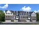 Charming townhome exteriors with a stone facade, multiple windows, and attached garages for convenient parking at 2885 Foster Woods Dr, Apex, NC 27502