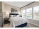 Comfortable bedroom featuring neutral walls, bright windows, a king bed, and stylish bedside lamps at 2889 Foster Woods Dr, Apex, NC 27502