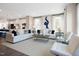 Spacious living room with plush white sofas, stylish decor, and an open view of the adjacent kitchen at 2889 Foster Woods Dr, Apex, NC 27502