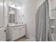 Clean bathroom with a white vanity, tiled floors, and shower with a patterned curtain at 330 Macallan Dr, Burlington, NC 27215
